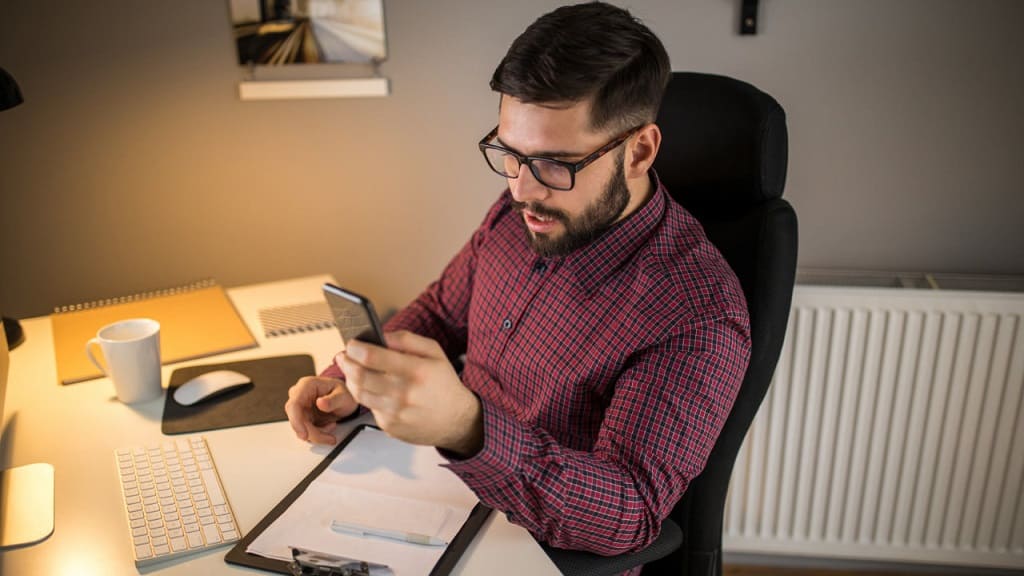 man checking cell phone while working